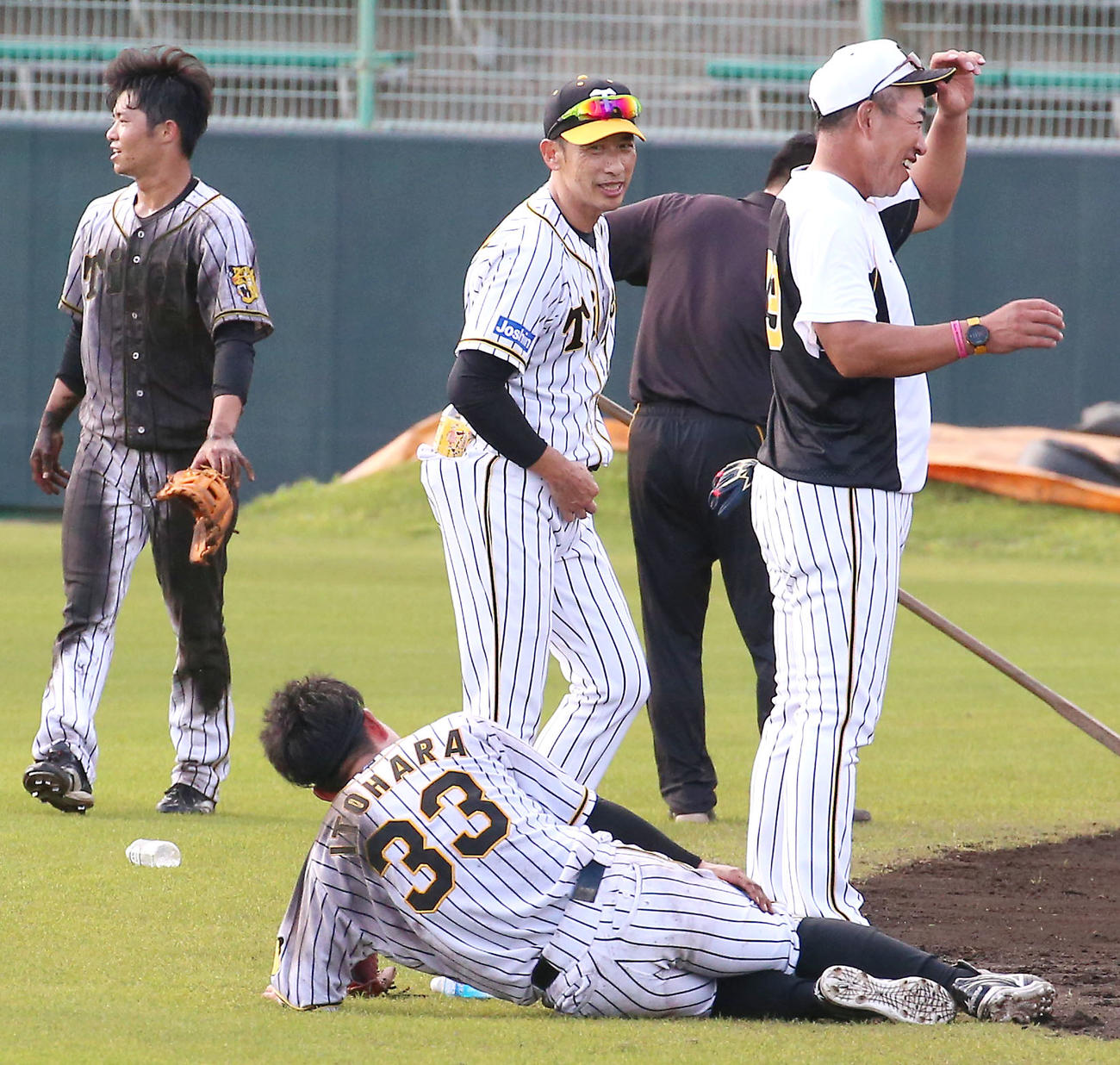 矢野監督（中央）のデスノックが終わり倒れ込む糸原（手前）左は泥まみれの中野（撮影・上山淳一）
