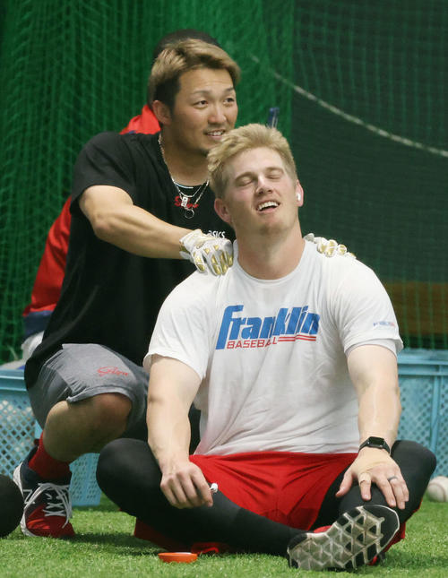 広島沖縄キャンプ　練習の合間にクロンの肩をもむ鈴木誠。「お客さん。凝ってますねぇ」「極楽、極楽・・・」って感じでしょうか（撮影・加藤孝規）