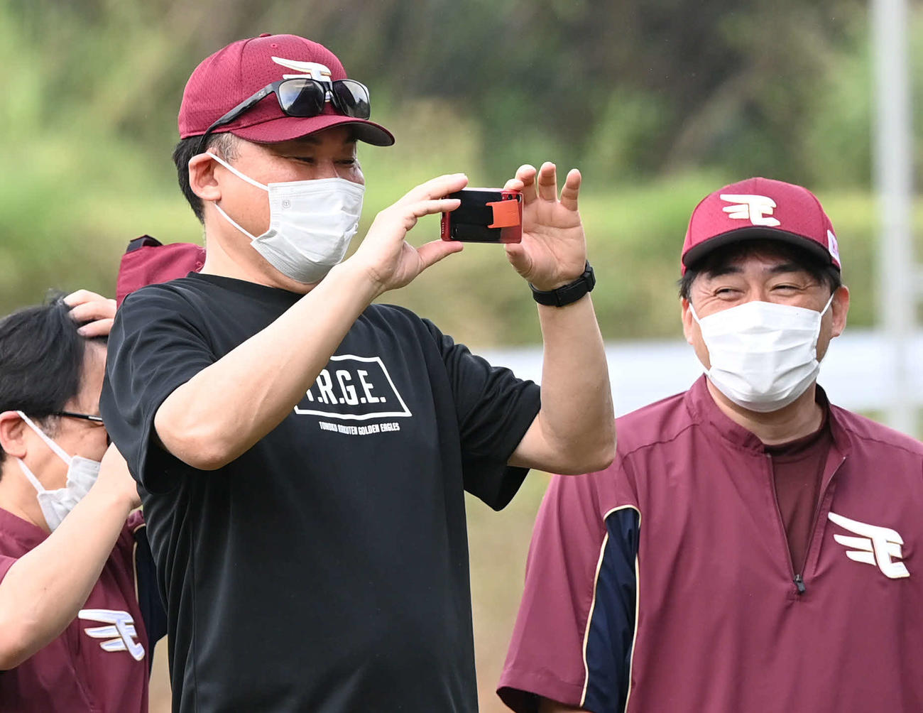 ブルペンを撮影する楽天三木谷オーナー。右は石井GM兼監督（撮影・山崎安昭）