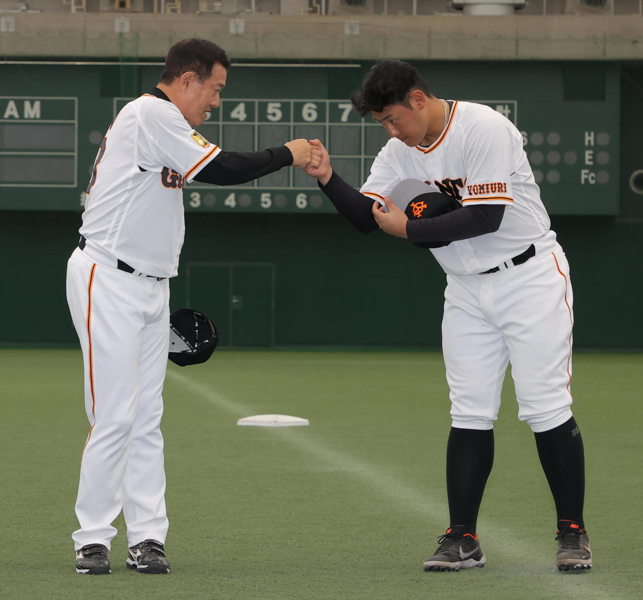 宮崎1次キャンプを打ち上げタッチを交わす巨人の原監督（左）と岡本和