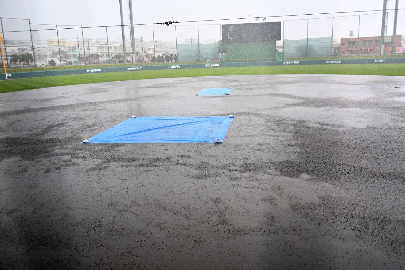 突然の大雨で水浸しになったコザしんきんスタジアムのグラウンド（撮影・上田博志）