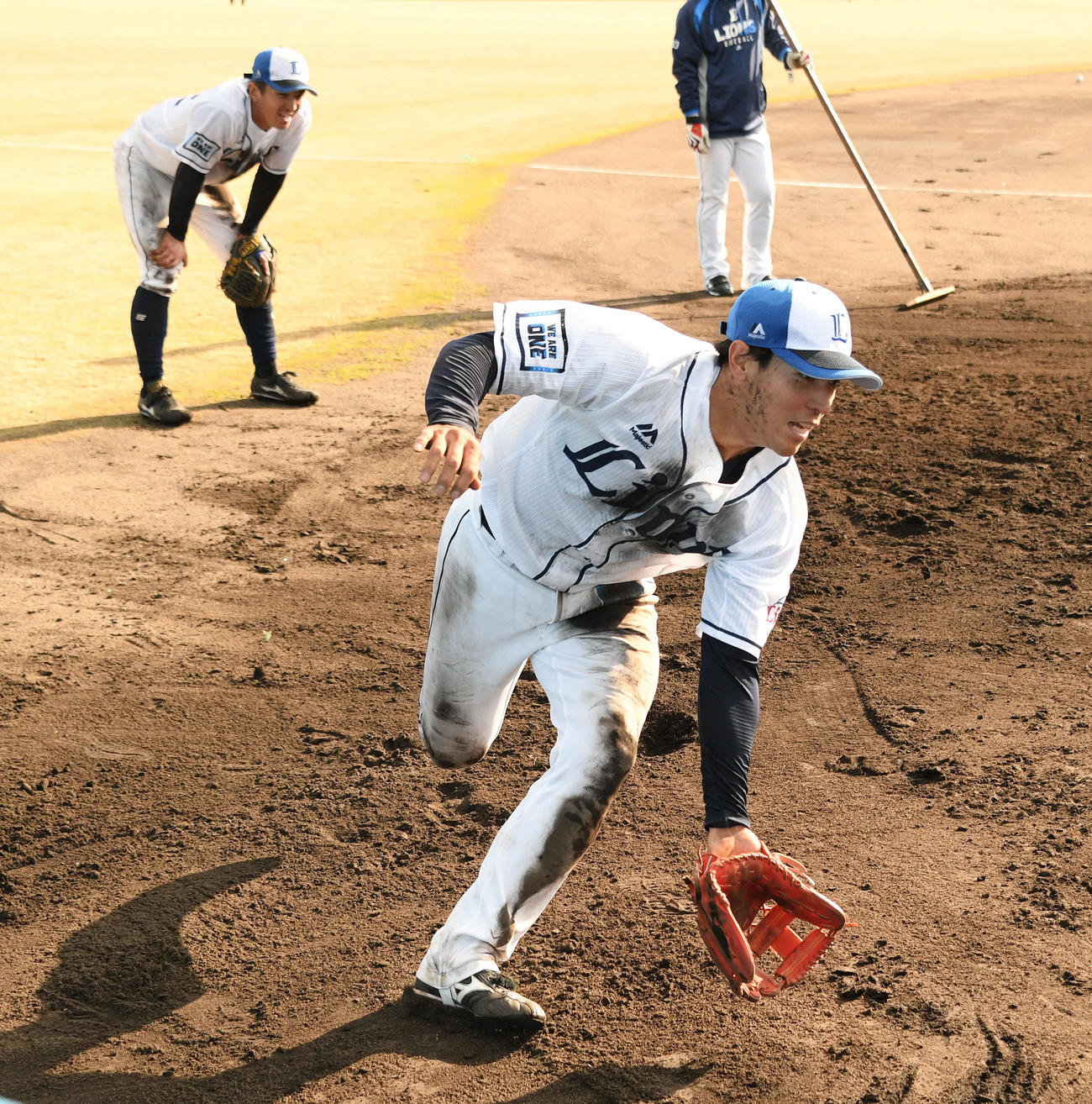 泥まみれになりながら特守で汗を流す西武山野辺（手前）（撮影・滝沢徹郎）