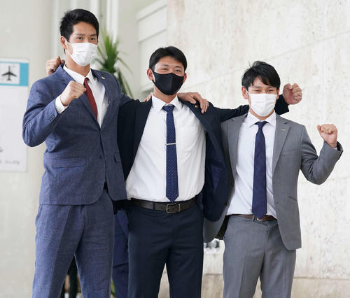 那覇に到着し笑顔でガッツポーズする巨人の、左から秋広、平内、伊藤優（撮影・鈴木みどり）