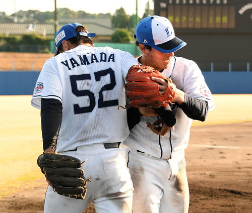 泥まみれになった特守を終え西武山野辺（右）は山田と抱き合う（撮影・滝沢徹郎）