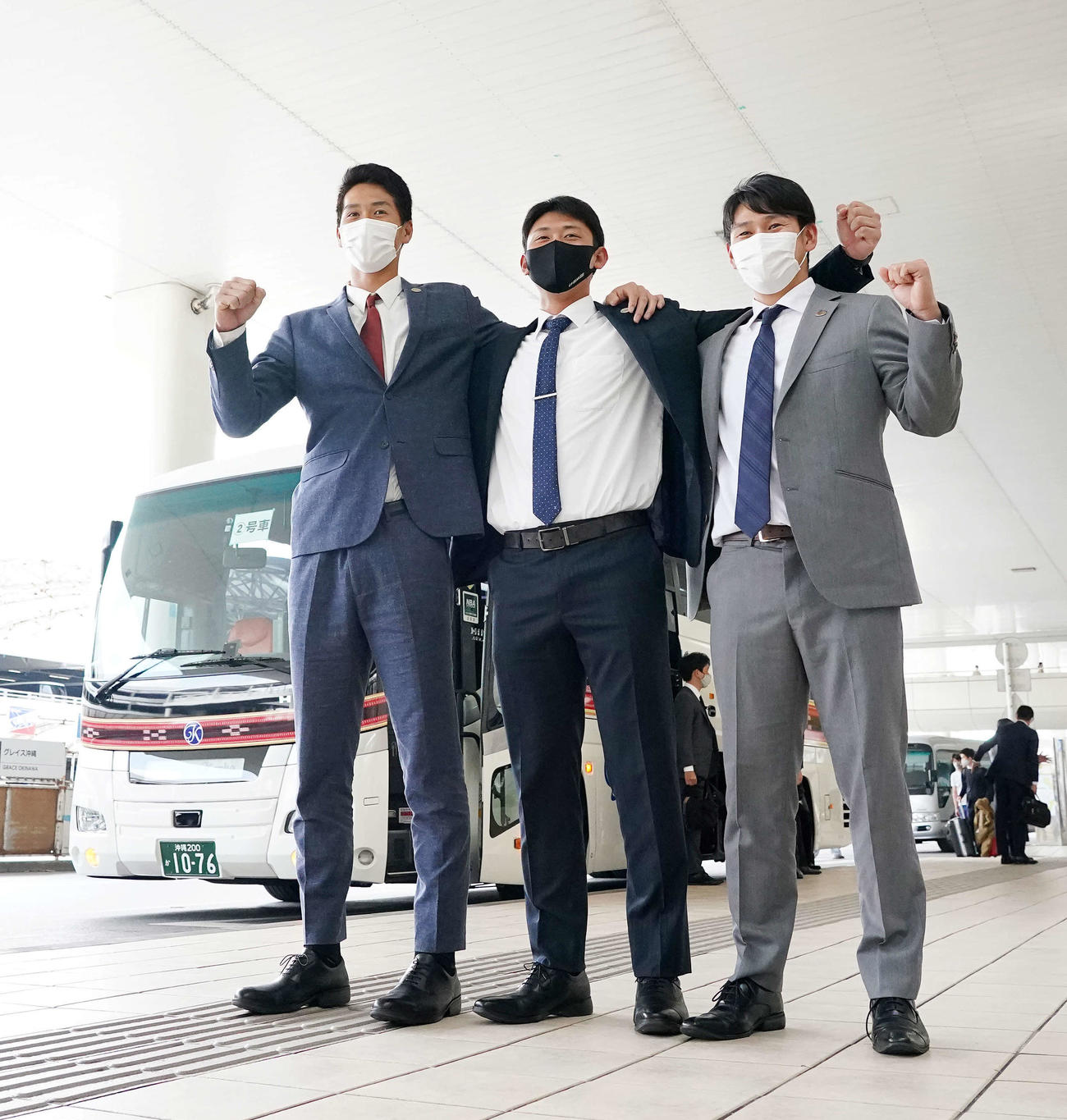 沖縄に到着しガッツポーズを見せる巨人新人選手たち。左から秋広、平内、伊藤優（撮影・江口和貴）