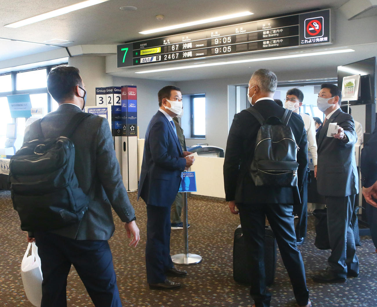 航空券の手続きが遅れ搭乗口付近で待つ巨人原監督（左から2人目）（撮影・足立雅史）