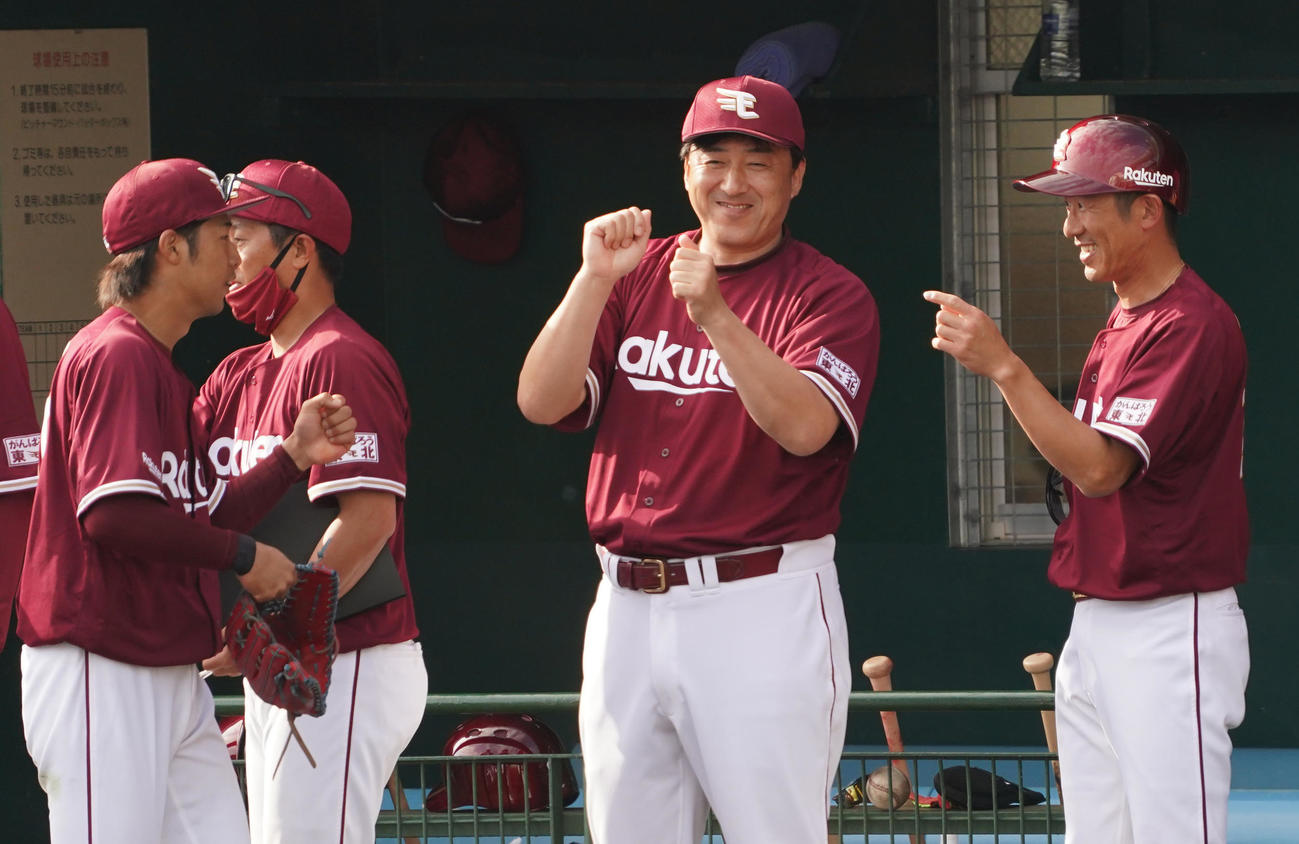 阪神との練習試合で引き分けに終わり、ナインを笑顔で迎える楽天石井GМ兼監督（右から2人目）（撮影・菅敏）