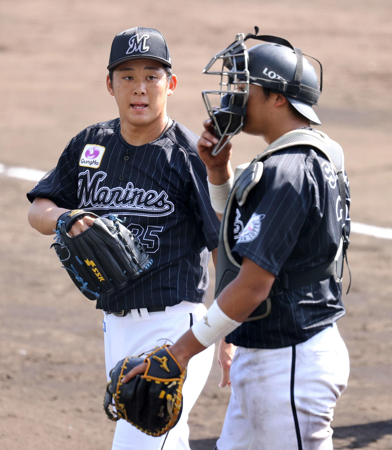 広島対ロッテ　5回裏、広島の攻撃を抑え佐藤都（右）と話ながら引き揚げるロッテ鈴木（撮影・鈴木正人）