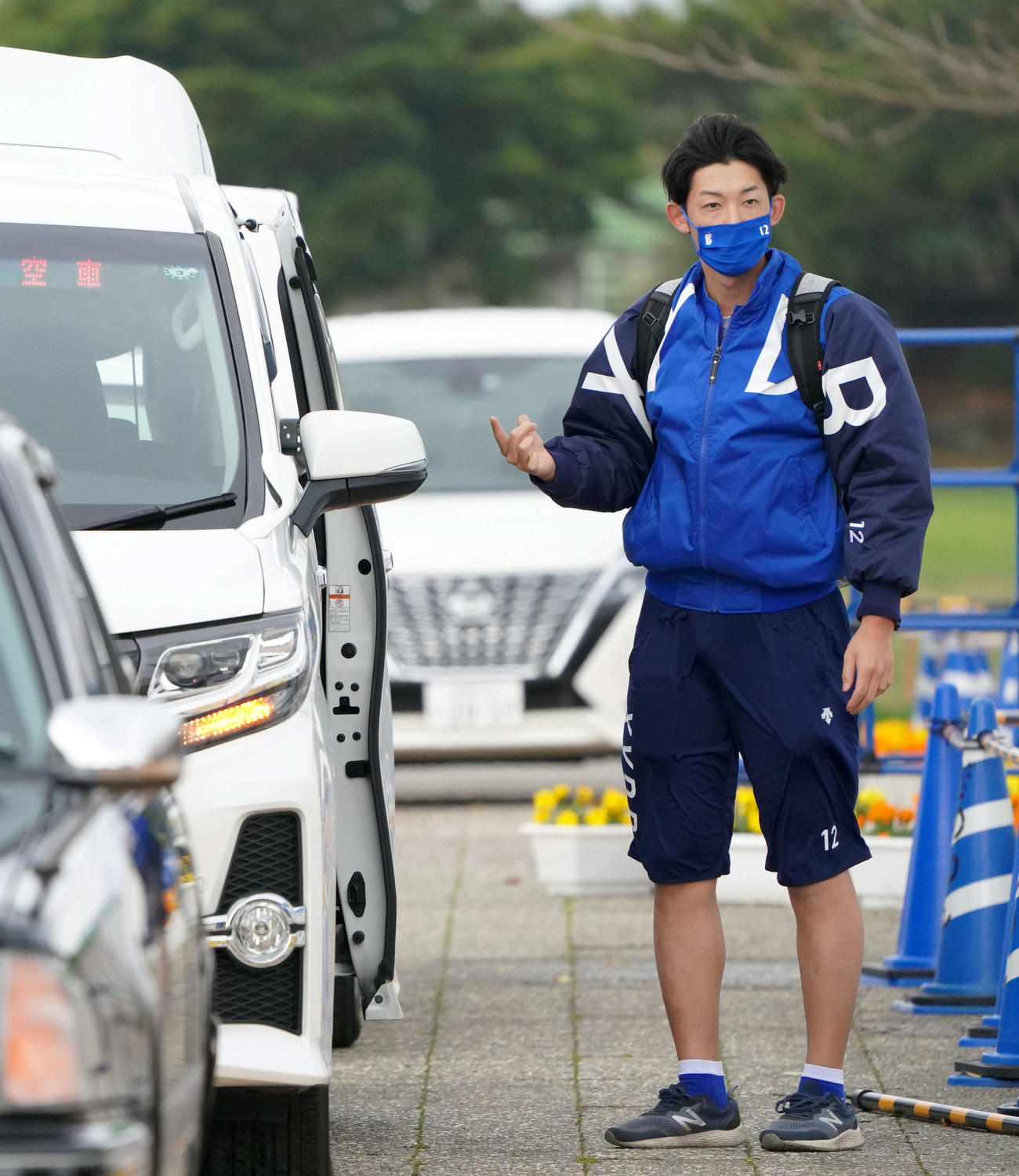 ヤクルト対DeNA　沖縄では珍しいぐらいの寒空の下、ハーフパンツで試合会場へ向かうDeNA阪口（撮影・横山健太）