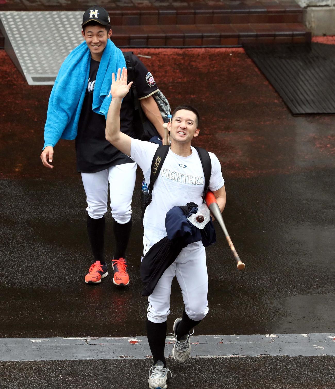 雨天中止　練習を終え手を振って引き揚げる日本ハム杉谷拳士（手前）と石井一成（2020年9月12日撮影）
