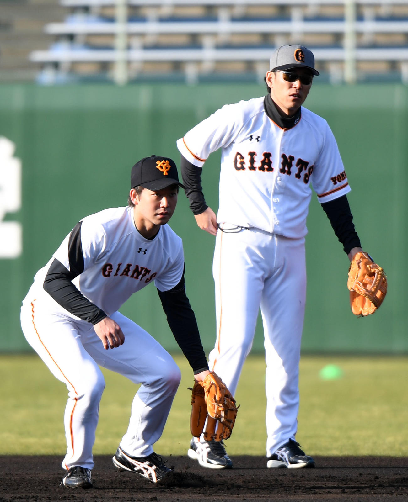 17年春季キャンプ、早出ノックで井端コーチ（右）から二塁の守備を教わる山本