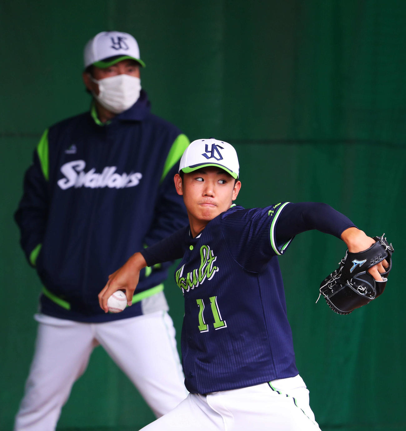 ブルペン投球するヤクルト奥川。後方左は高津監督（撮影・河田真司）