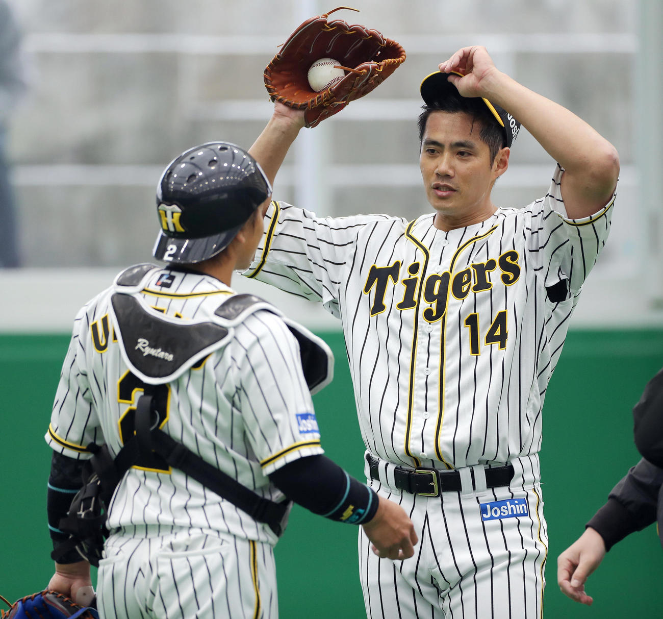 ブルペンで投球を終え、阪神梅野（左）と話し合うチェン（撮影・前田充）