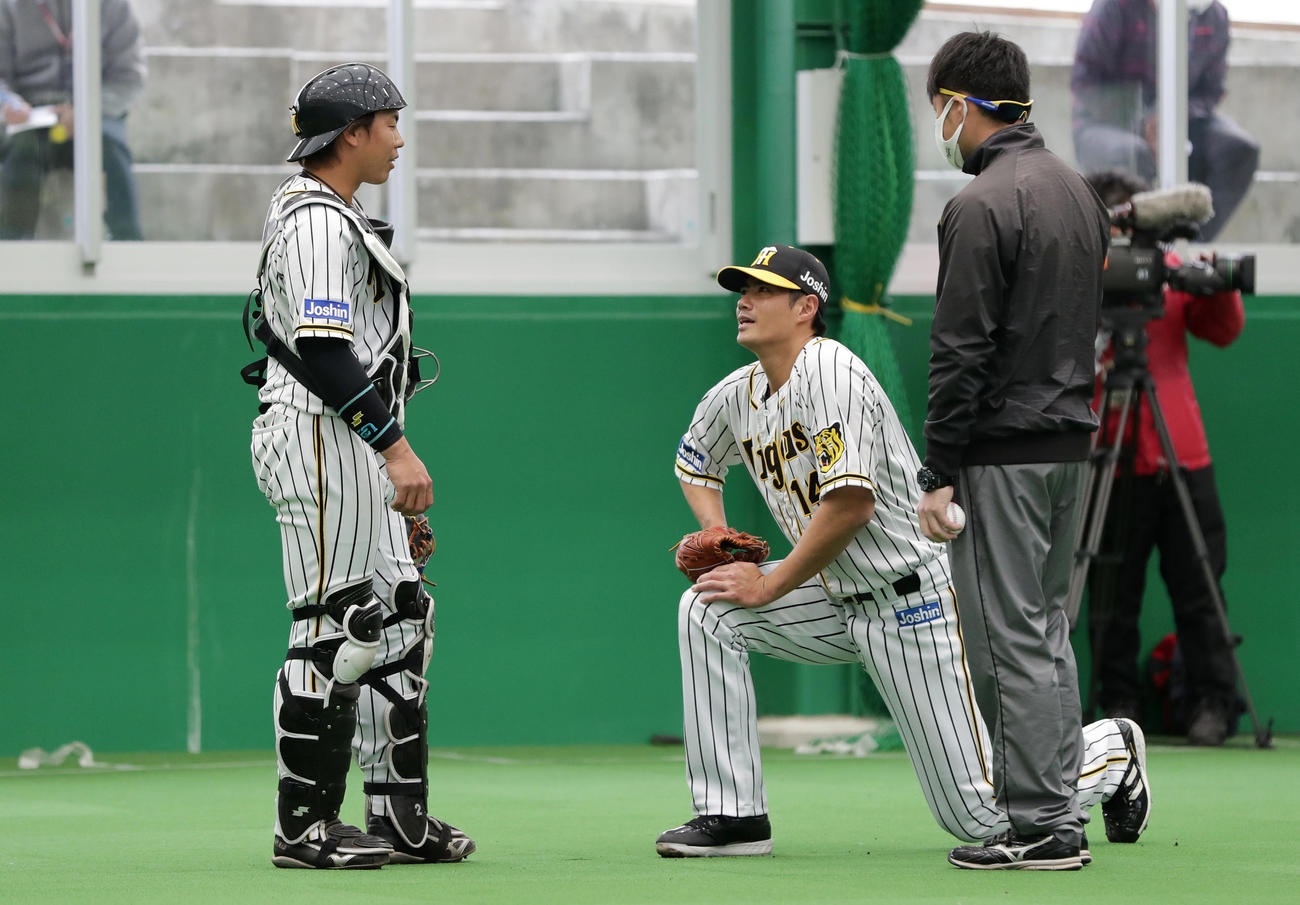 ブルペンで投球を終え、阪神梅野（左）と言葉を交わすチェン（中央）（撮影・前田充）