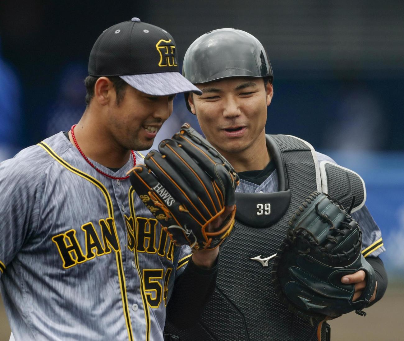 DeNAとの練習試合で笑顔で引き揚げる阪神栄枝（右）と加治屋のバッテリー（共同）