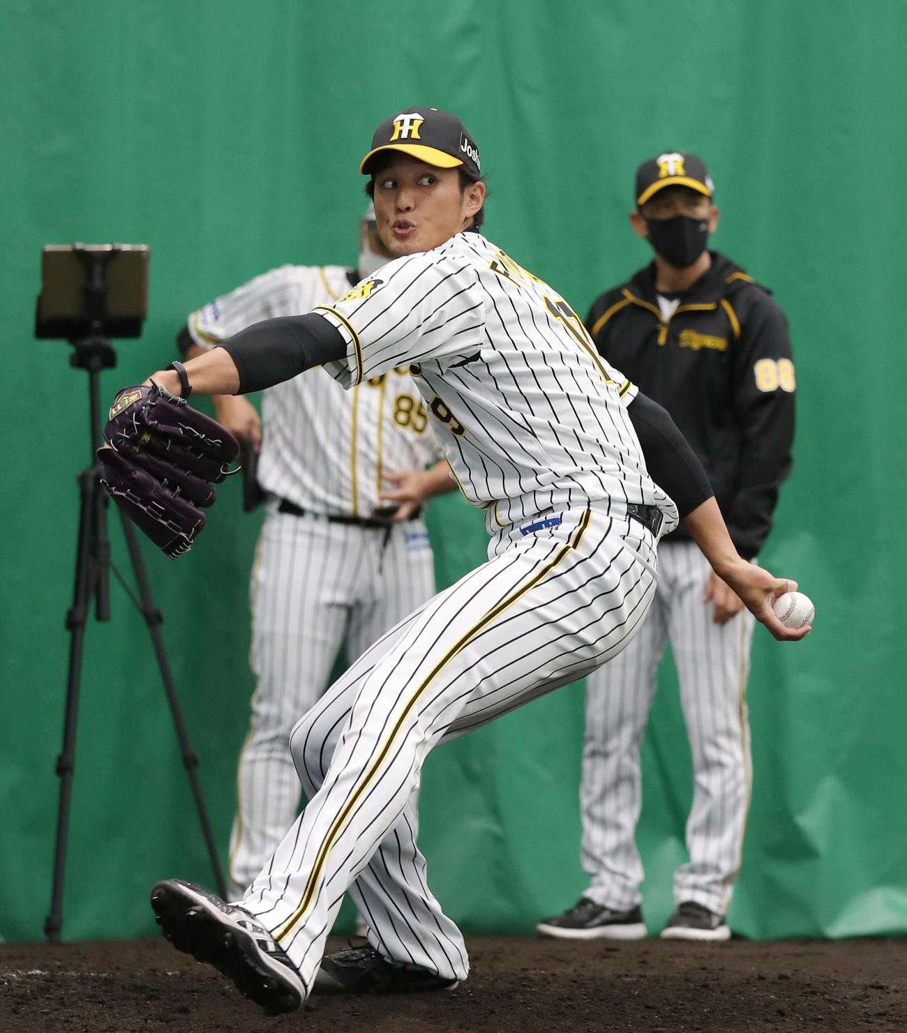 ブルペンで阪神矢野燿大監督（後方右）が見つめる前で投球する藤浪晋太郎（2021年2月11日撮影）