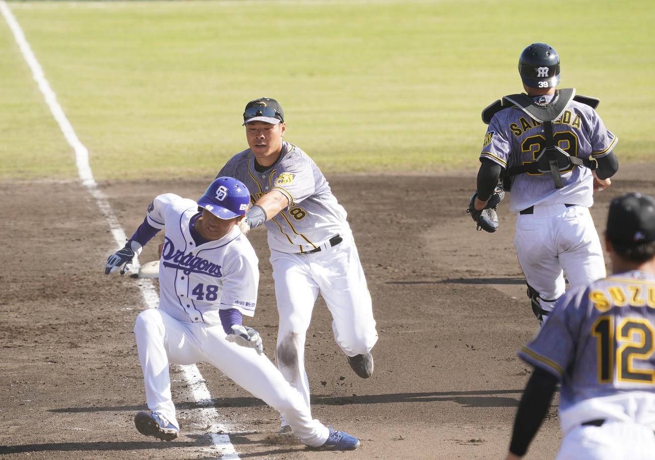 練習試合　中日対阪神　8回裏中日無死一、三塁、藤井淳志の投ゴロで三塁走者溝脇隼人（左）を挟殺プレーでタッチアウトにする三塁手佐藤輝明（中央）（撮影・清水貴仁）