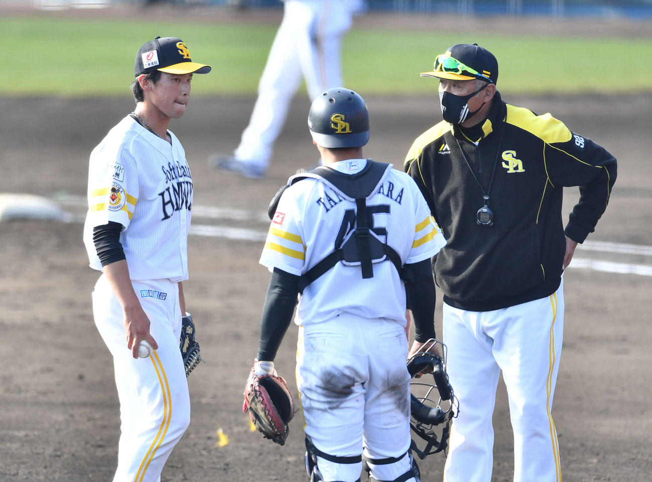 紅白戦　5回表紅組1死、海野を左飛に抑えた後に森山コーチ（右）からマウンドで声をかけられ、厳しい表情を見せる尾形（左）、中央は谷川原（撮影・岩下翔太）