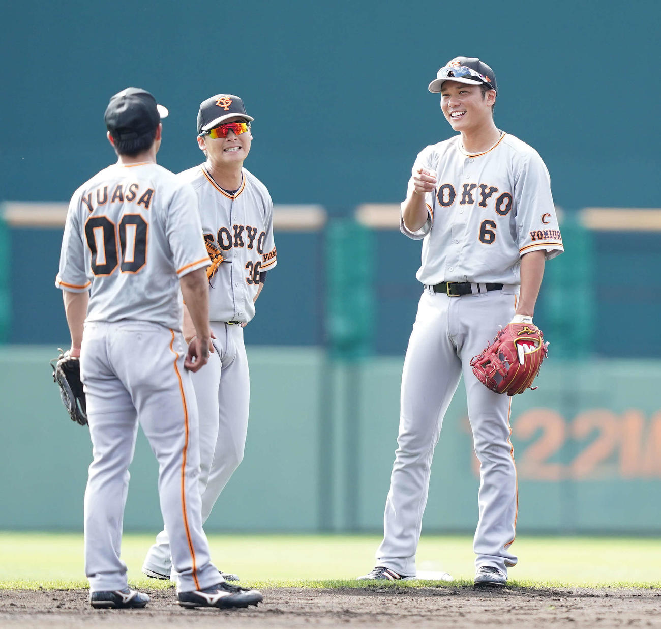 ノックの合間に湯浅（左）、石川（中央）と談笑する巨人坂本（撮影・鈴木みどり）