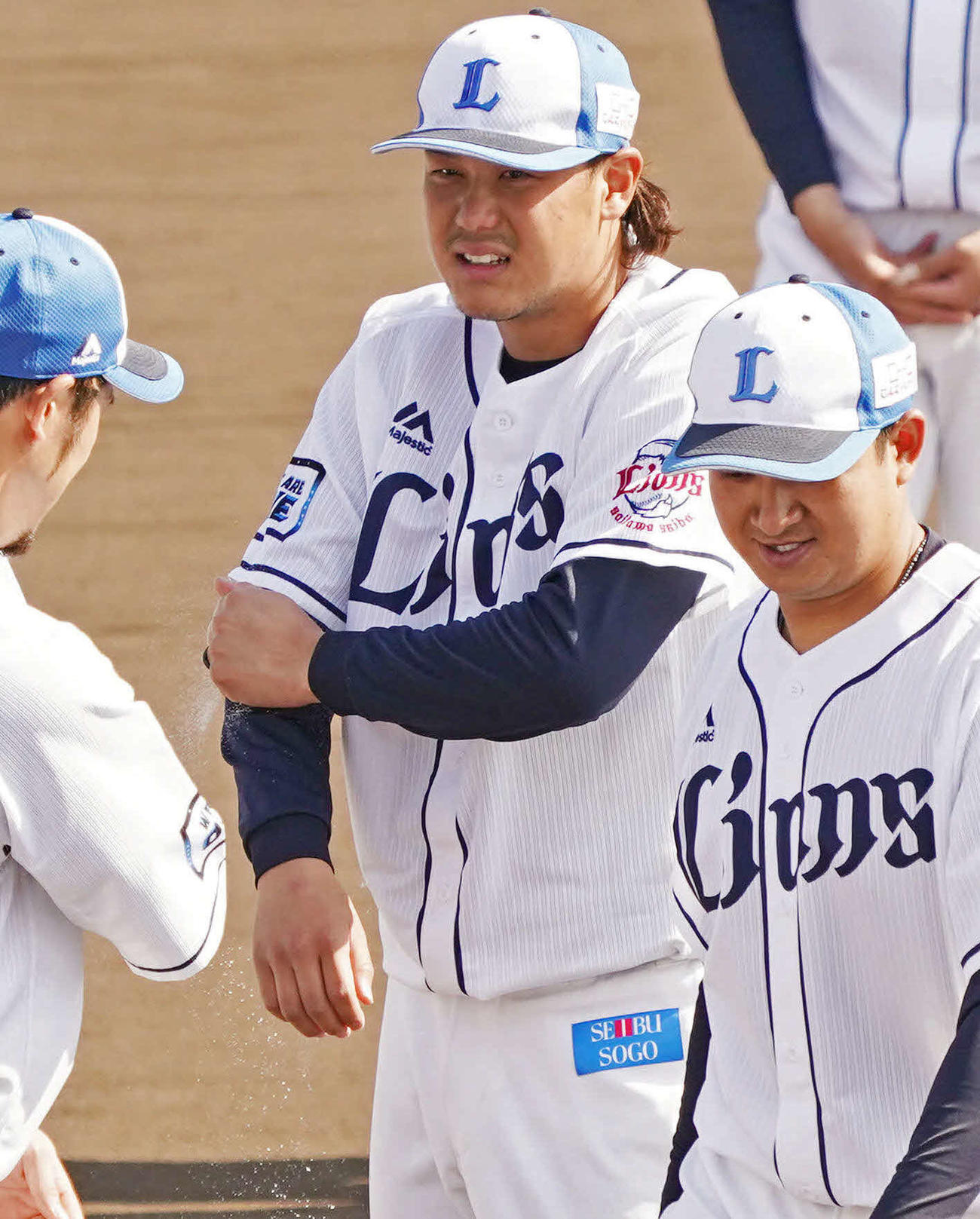 キャンプを打ち上げ、盛り塩を肘にすり込む開幕投手に指名された西武高橋（中央）（撮影・滝沢徹郎）