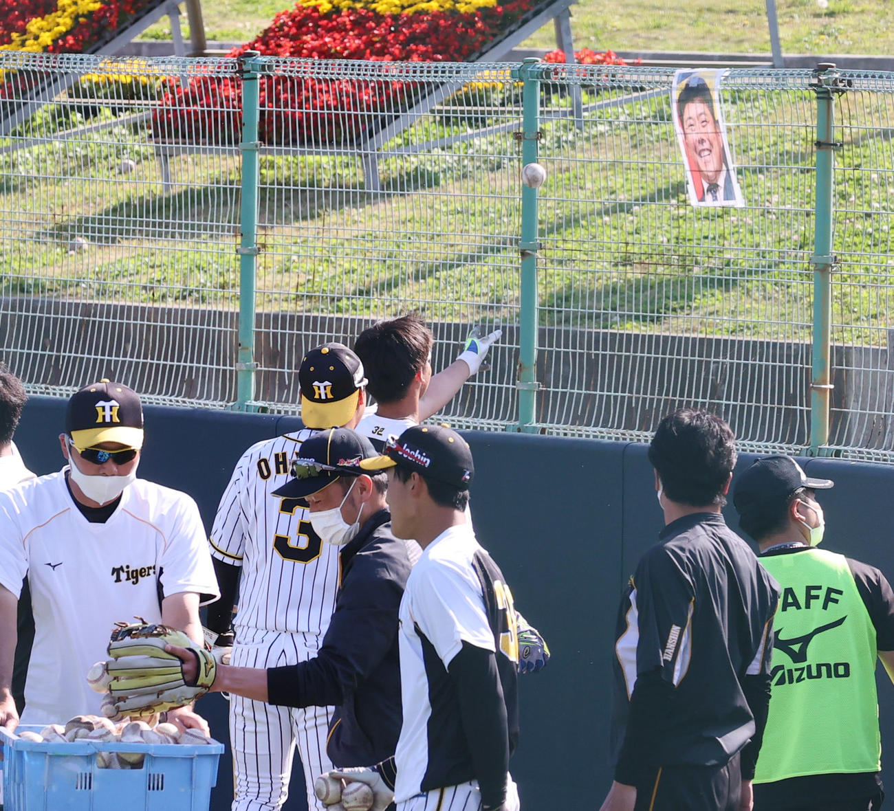 北川打撃コーチの顔写真にボールを投げて当てる井上（中央奥）（撮影・清水貴仁）