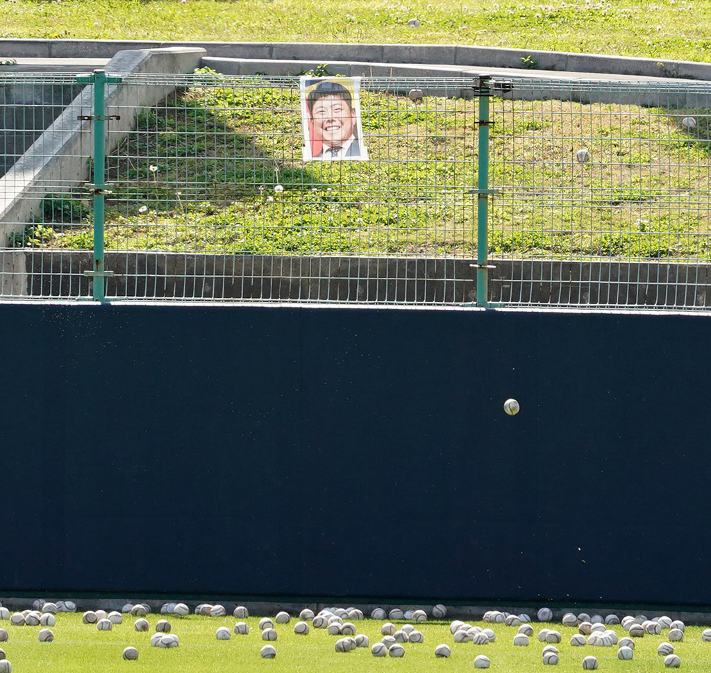 ロングティーの的として外野フェンスに貼られた北川打撃コーチの写真（撮影・清水貴仁）