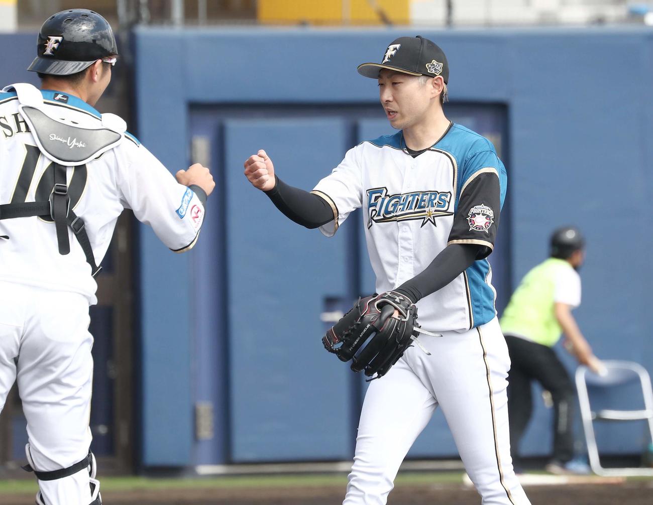練習試合　日本ハム対楽天　4回表、無失点に抑え清水（左）とタッチする金子（撮影・黒川智章）