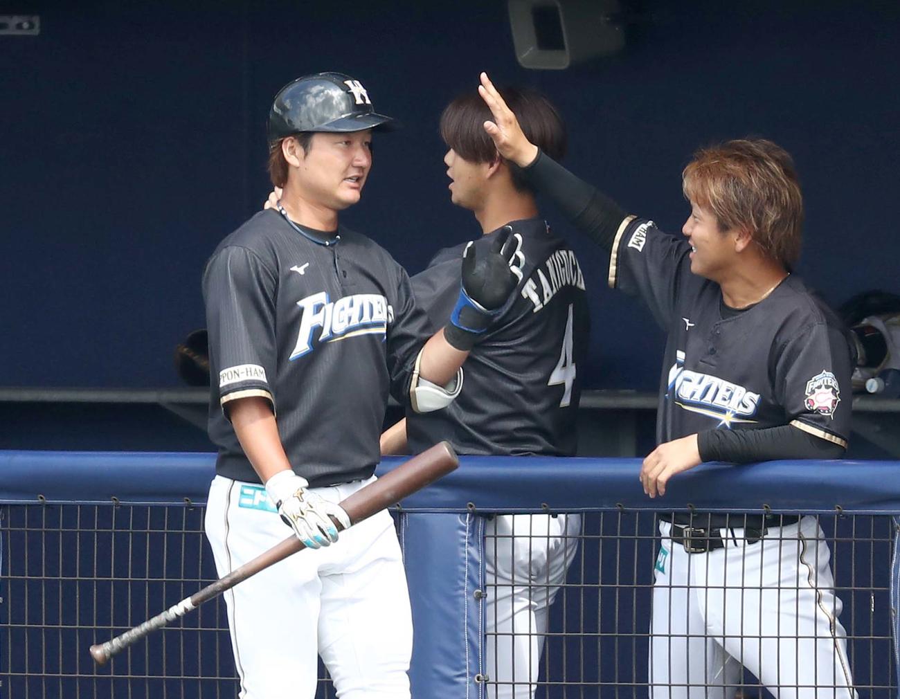 日本ハム紅白戦　3回表2死一、二塁、右中間に3点本塁打を放ち出迎えられる渡辺（撮影・黒川智章）