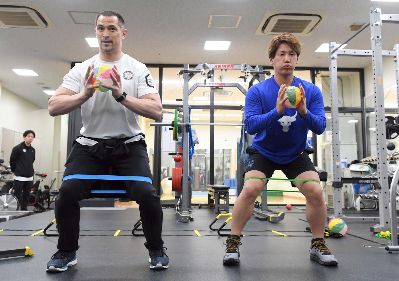 19年1月、室伏広治氏（左）の指導を受け紙風船を使ってトレーニングするオリックス吉田正