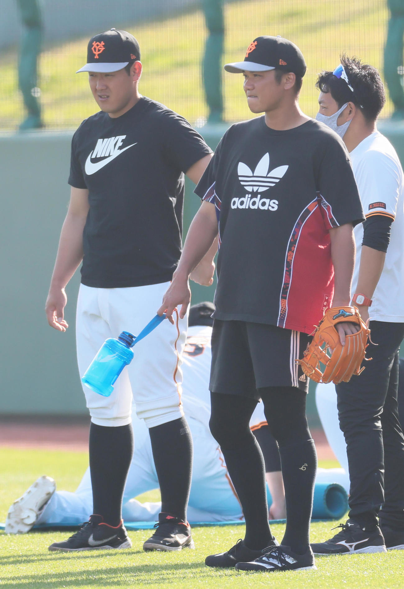 全体練習前、体を動かす巨人の岡本和（左）と坂本（撮影・足立雅史）