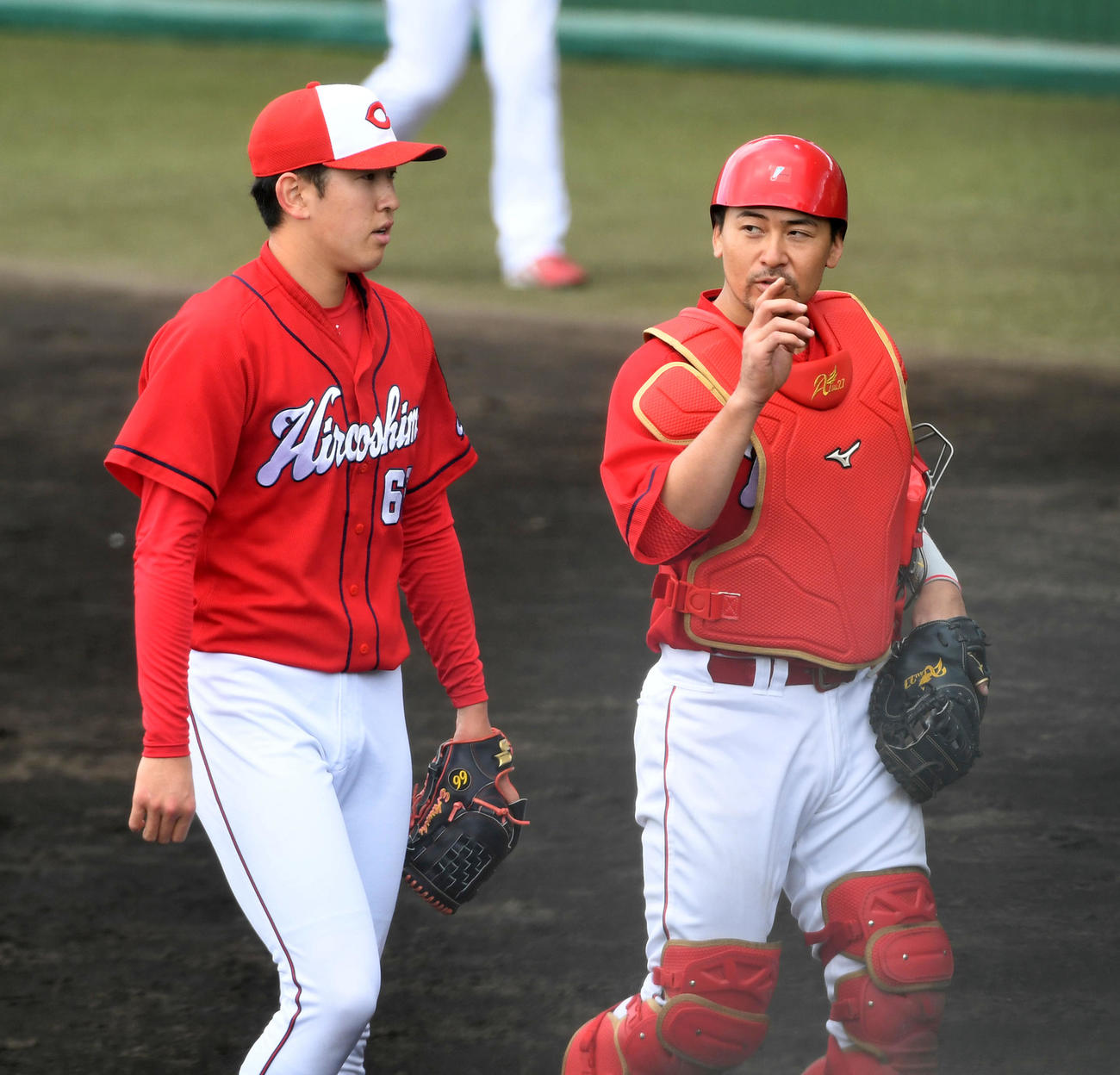 2回を終え会沢（右）と話しながらベンチに戻る広島遠藤（撮影・前岡正明）