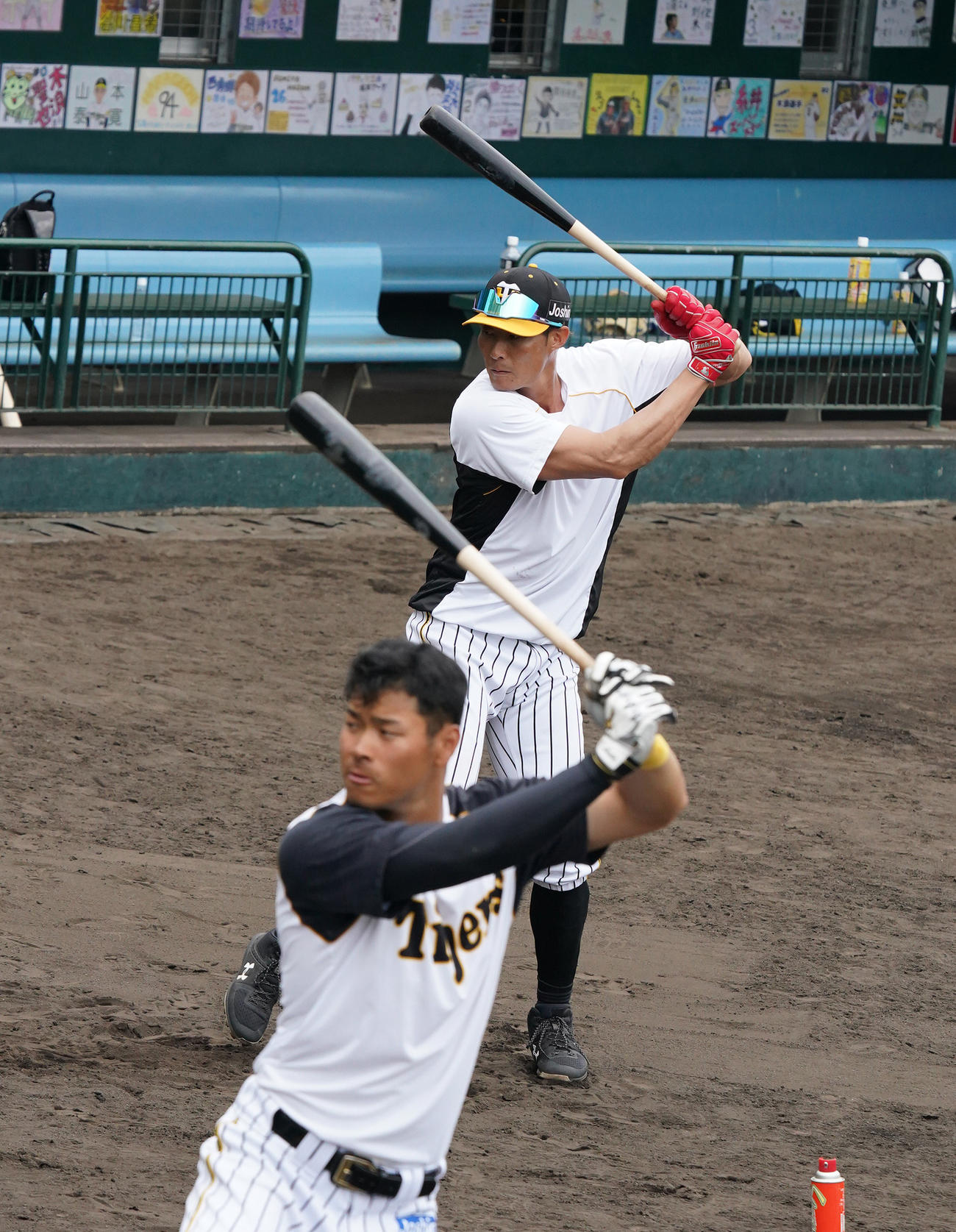 佐藤輝明（手前）のバットを借りて打撃練習を行う糸井嘉男（撮影・清水貴仁）