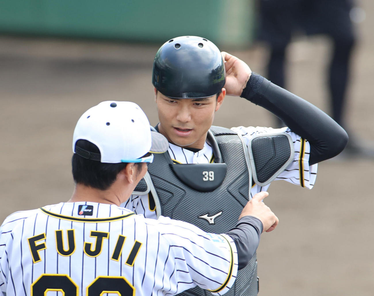 ケースシートノックで藤井バッテリーコーチ（手前）の指導を受ける栄枝（撮影・清水貴仁）
