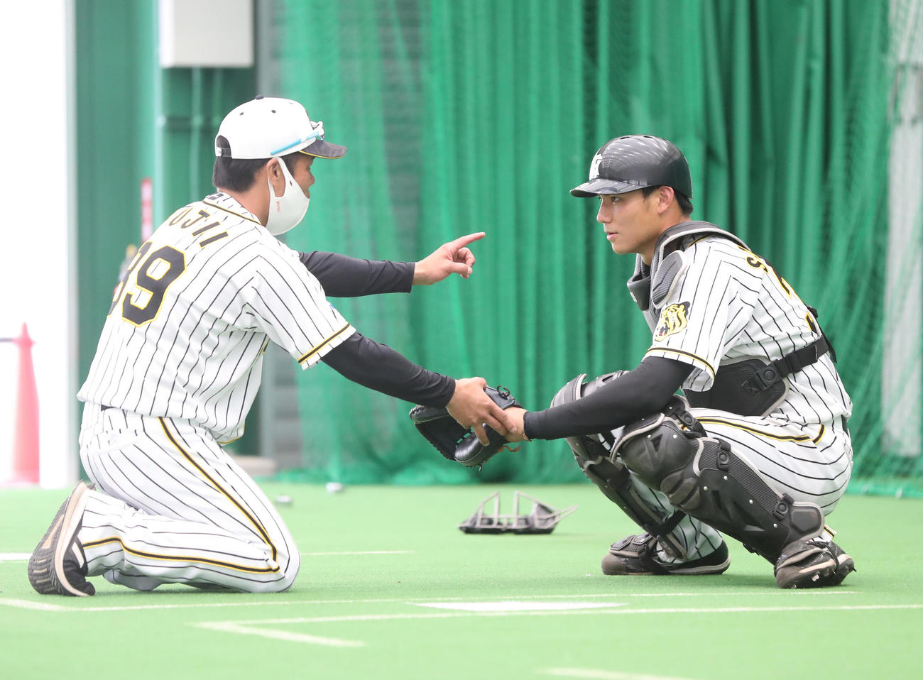 ブルペンで藤井バッテリーコーチ（左）から指導を受ける栄枝（代表撮影）