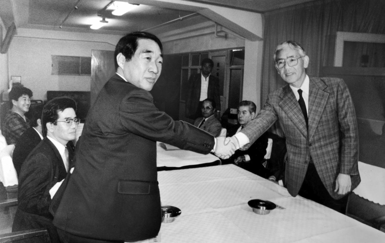 会議の席で「よろしくお願いします」と握手を交わす鵜木洋二新球団社長（左）とダイエー・杉浦忠監督＝1988年10