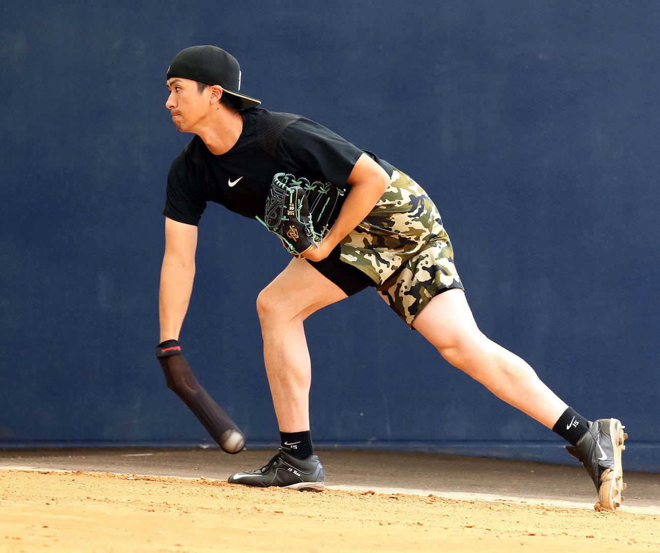 右手に投球用の練習器具を装着してシャドーピッチングする日本ハム上沢（撮影・黒川智章）