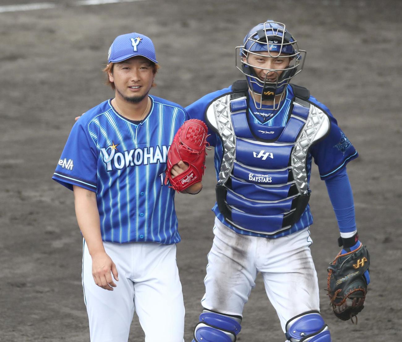 練習試合　日本ハム対DeNA 8回に登板し1失点の三嶋（左）は伊藤光に肩をたたかれる（撮影・黒川智章）