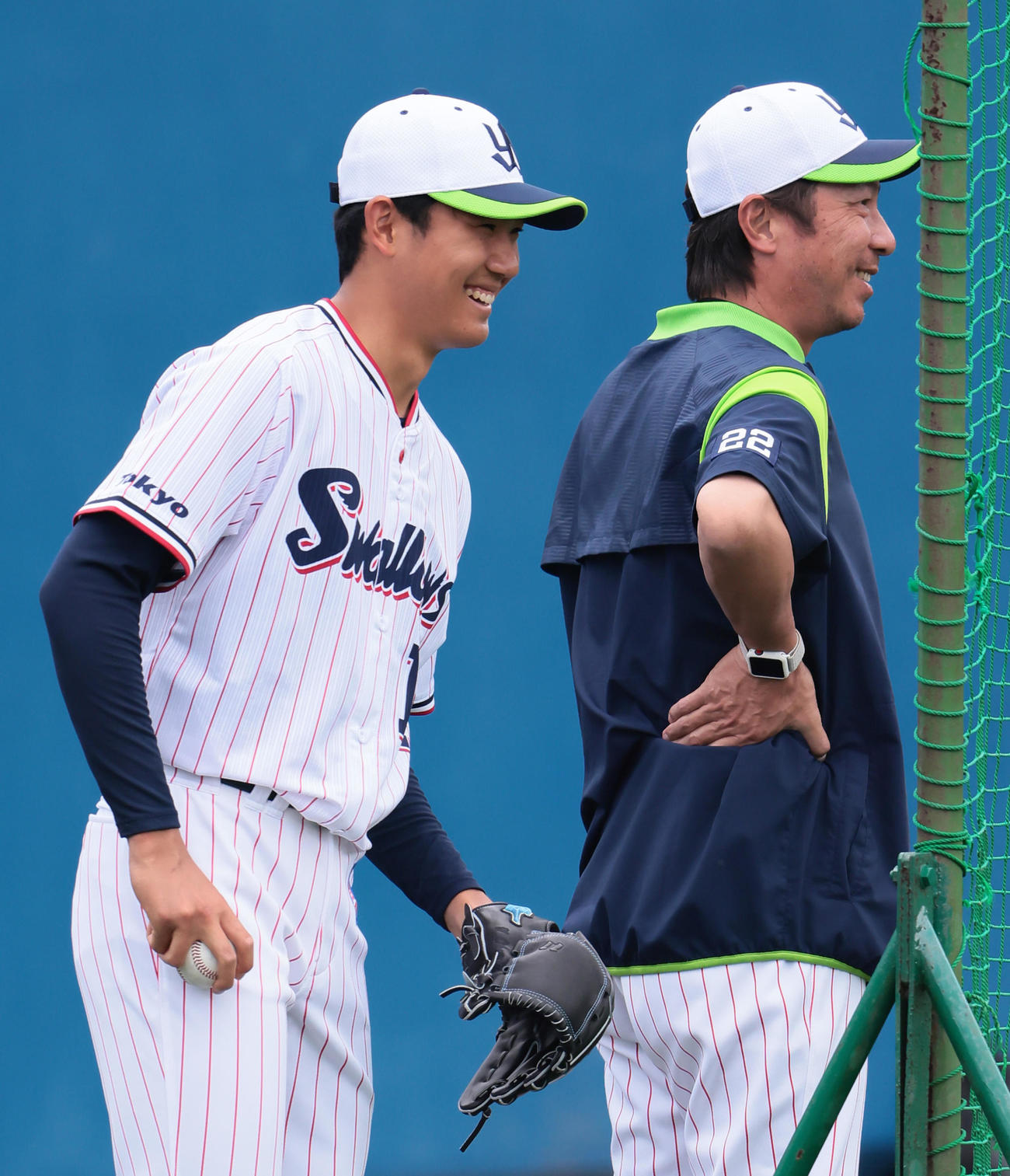 キャッチボールを終え笑顔で会話を交わすヤクルトの奥川（左）と高津監督（撮影・足立雅史）