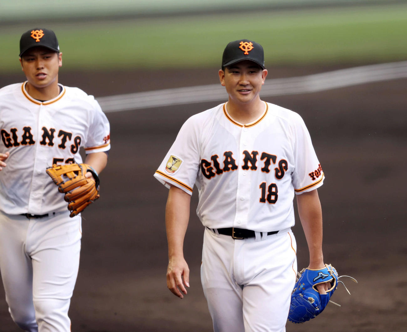 巨人対広島　2回表を終え、笑顔で引き揚げる菅野（右）。左は北村（撮影・狩俣裕三）