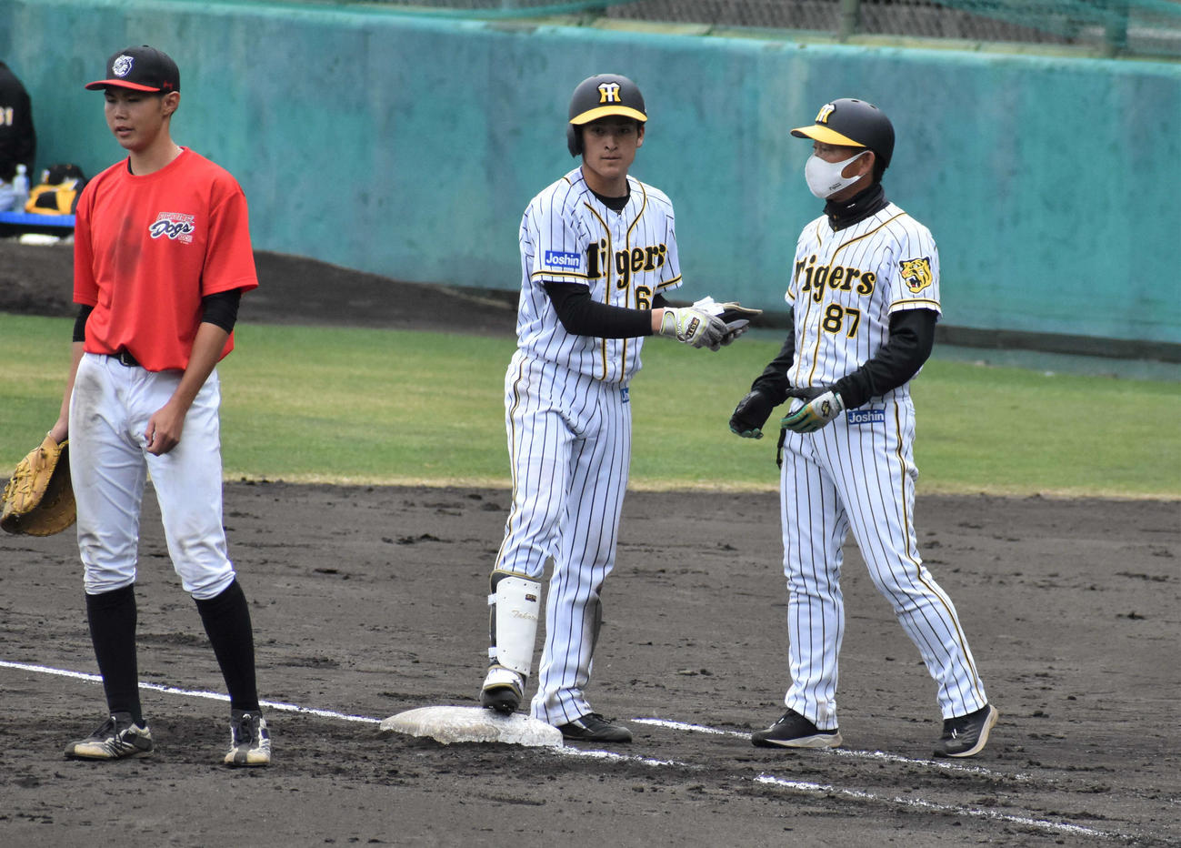 阪神2軍対四国IL高知　7回に右前打を放った阪神ドラフト7位の高寺。右は中村豊コーチ（撮影・只松憲）