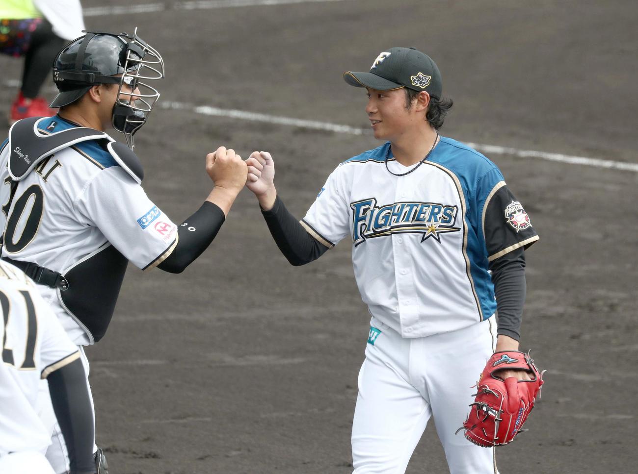 練習試合　日本ハム対広島　2回表、無失点に抑え宇佐見（左）とタッチする伊藤（撮影・黒川智章）