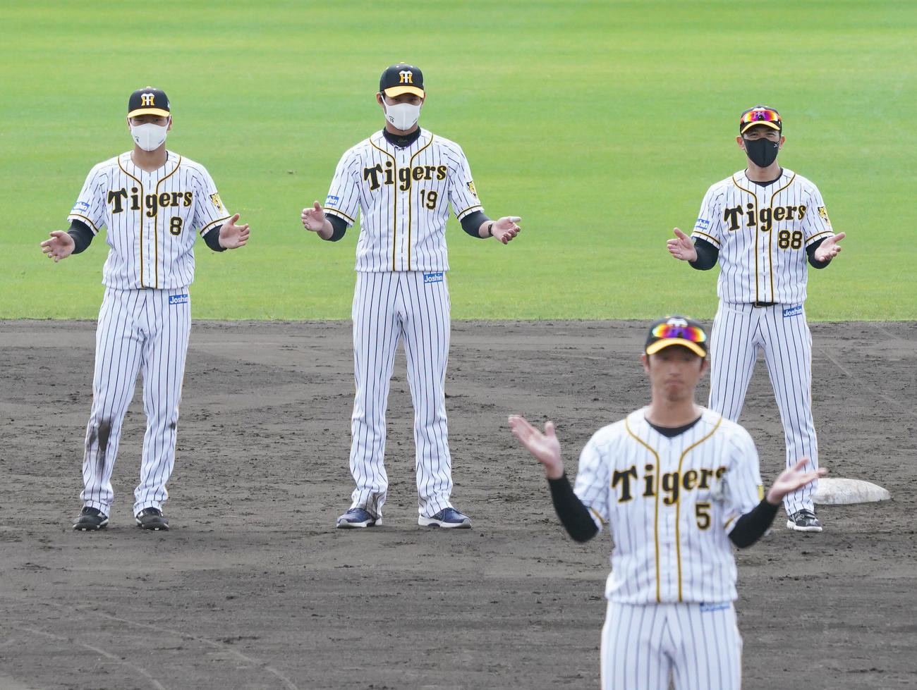 キャンプ打ち上げ、近本光司（手前）の音頭で手締めが行われる、奥左から佐藤輝明、藤浪晋太郎、矢野耀大監督（撮影・清水貴仁）