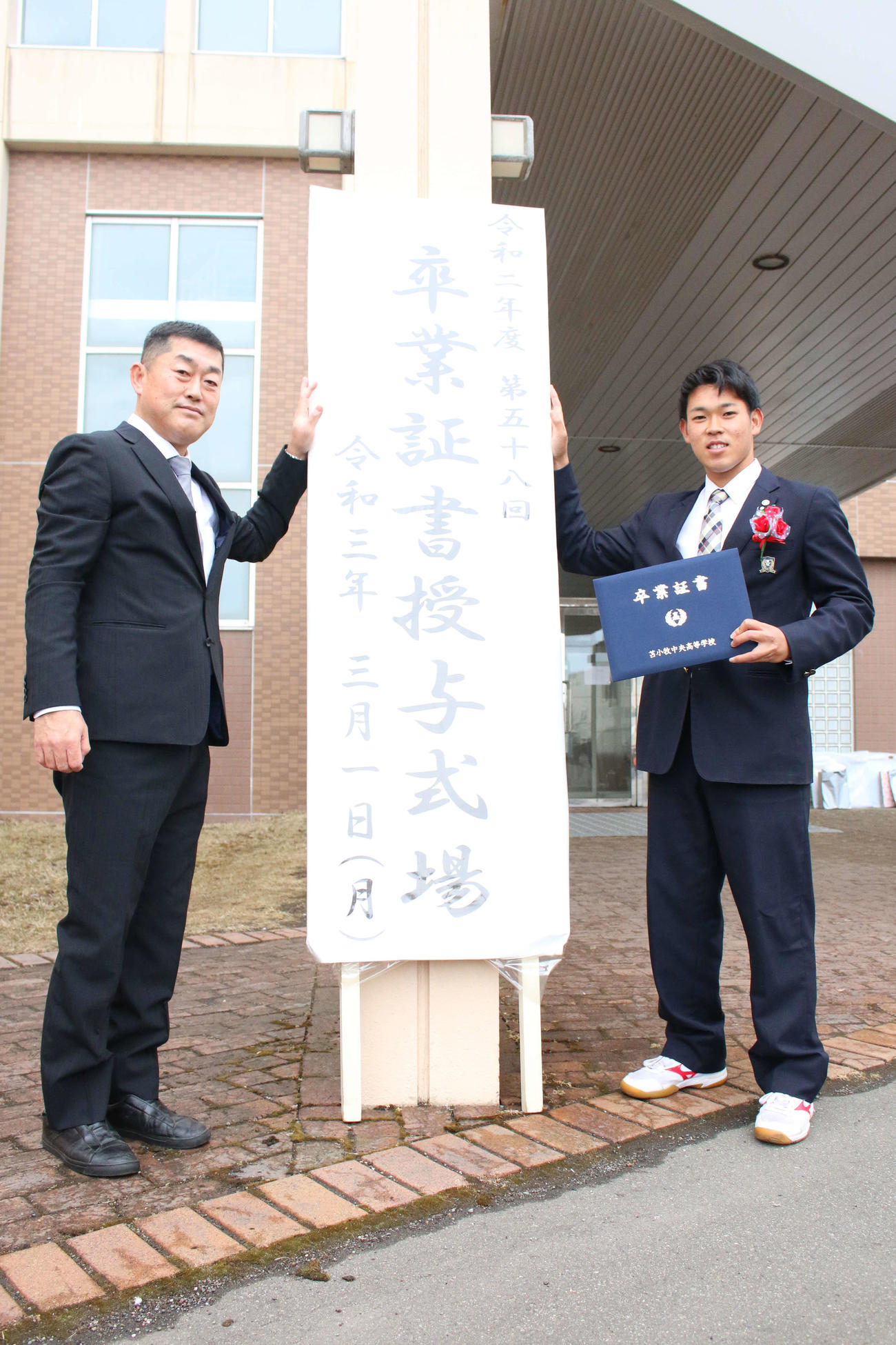 苫小牧中央の卒業式に出席した日本ハムのドラフト5位根本。左は野球部の渡辺監督（撮影・木下大輔）