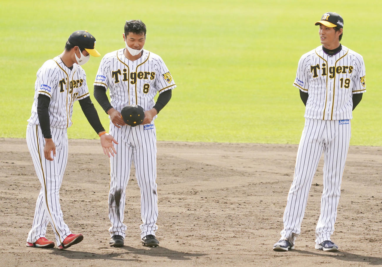 キャンプ最後の円陣で西純矢（左）と藤浪晋太郎（右）の間にうながされる佐藤輝明（撮影・清水貴仁）