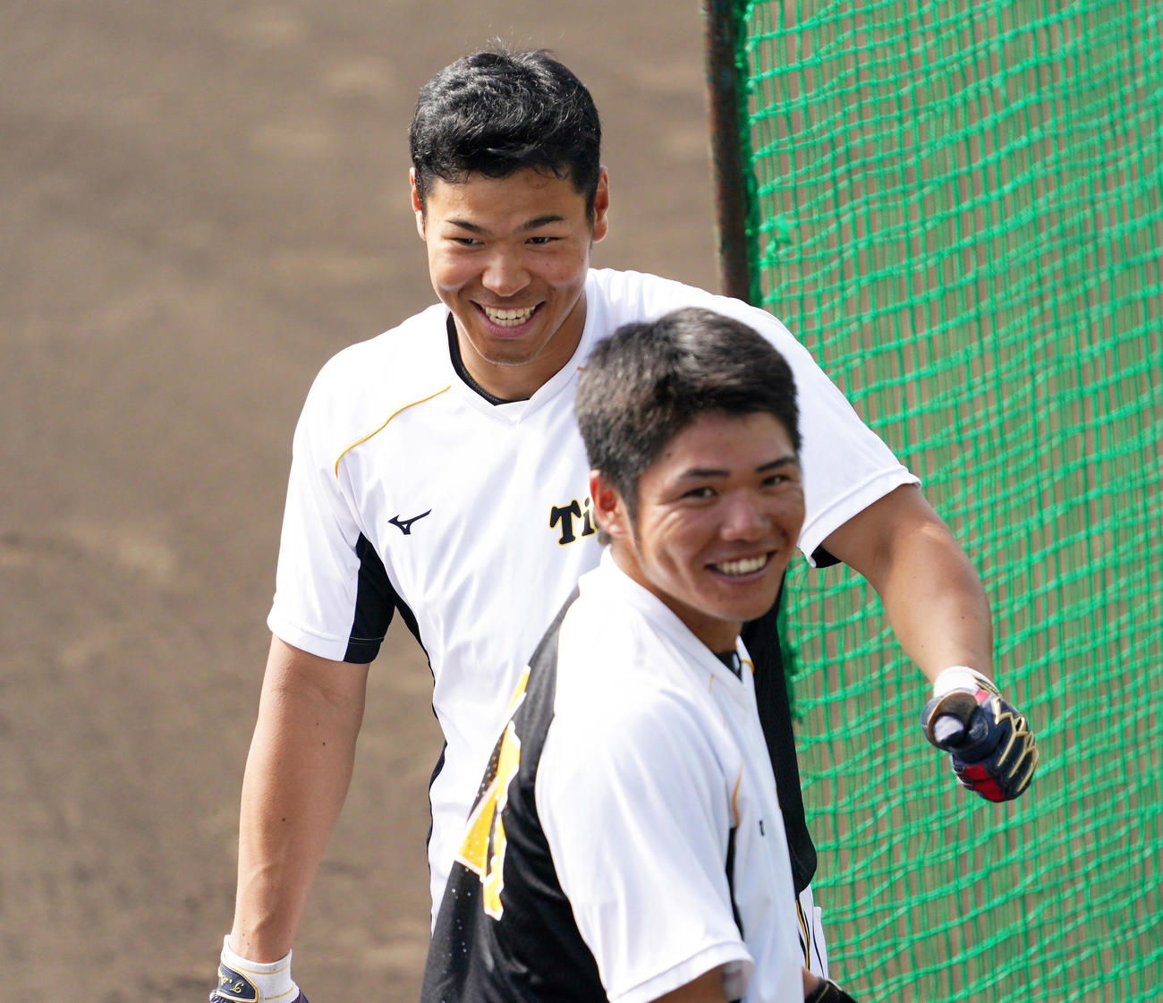 バント練習で笑顔をみせる佐藤輝明（奥）、小野寺暖（撮影・清水貴仁）