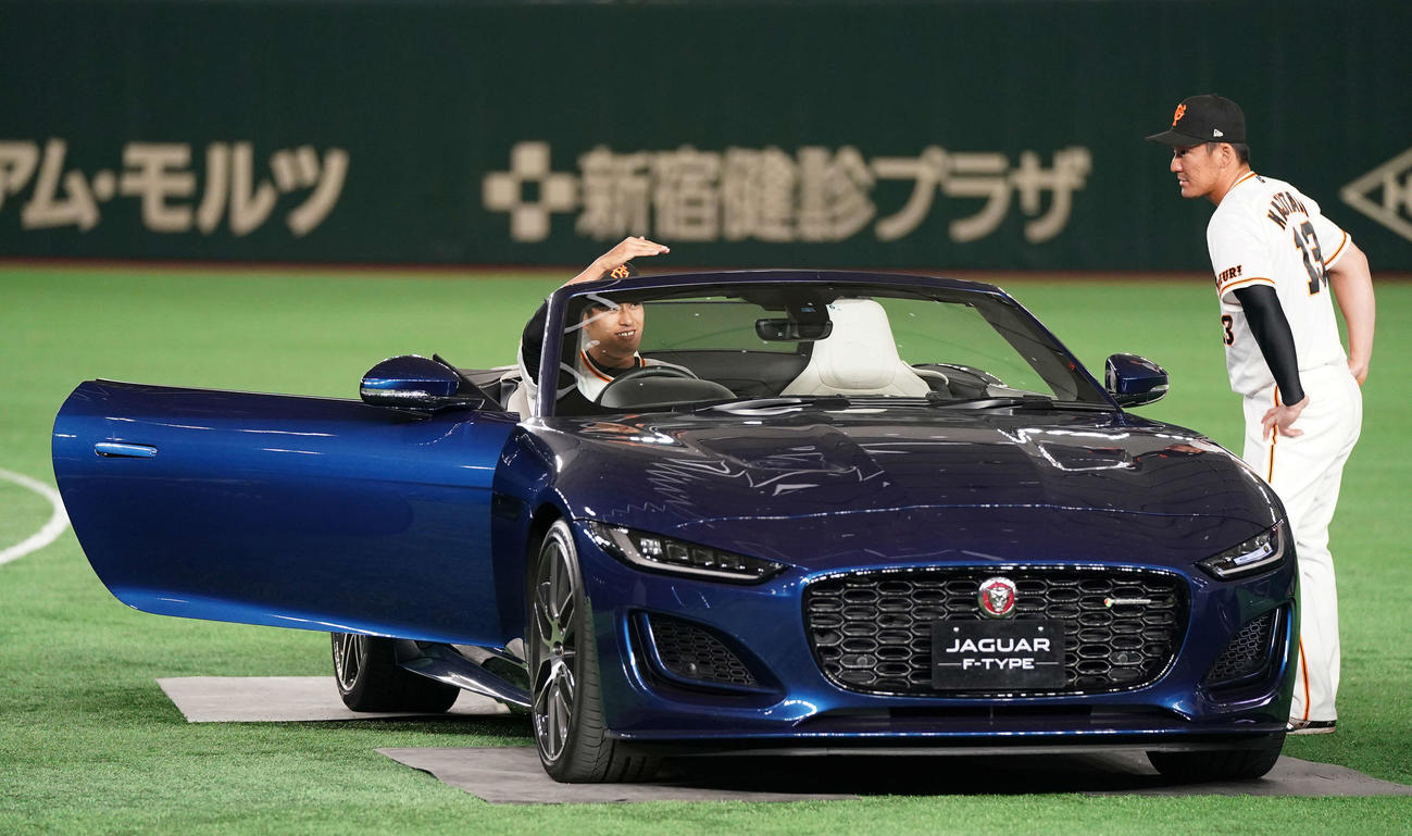 ジャガー貸与式で試乗する巨人井納（左）。右は梶谷（撮影・江口和貴）