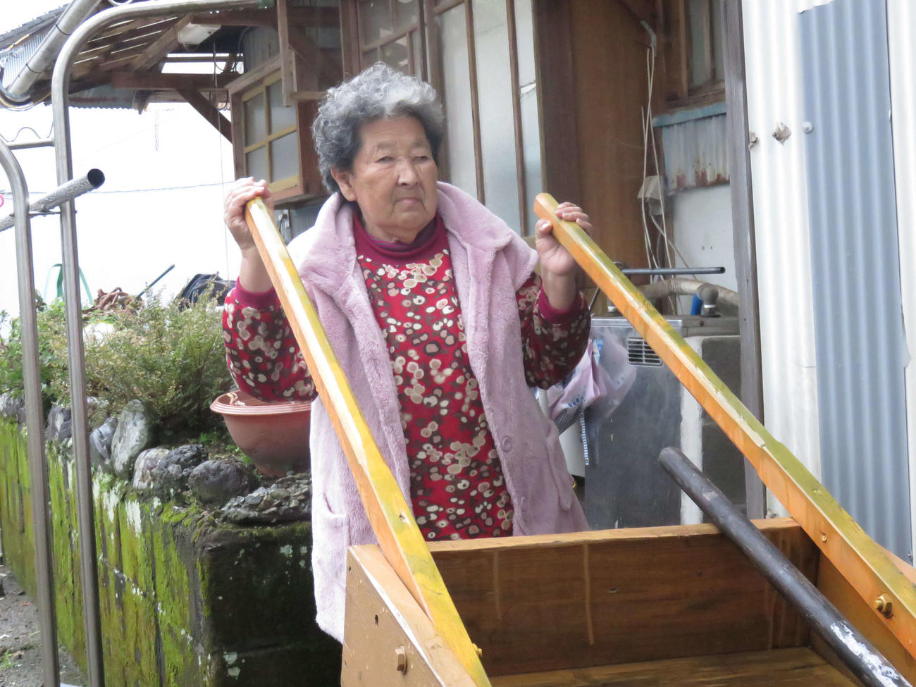 上田氏の母親あごさんの愛用したリヤカーをもつ次女香さん（撮影・寺尾博和）