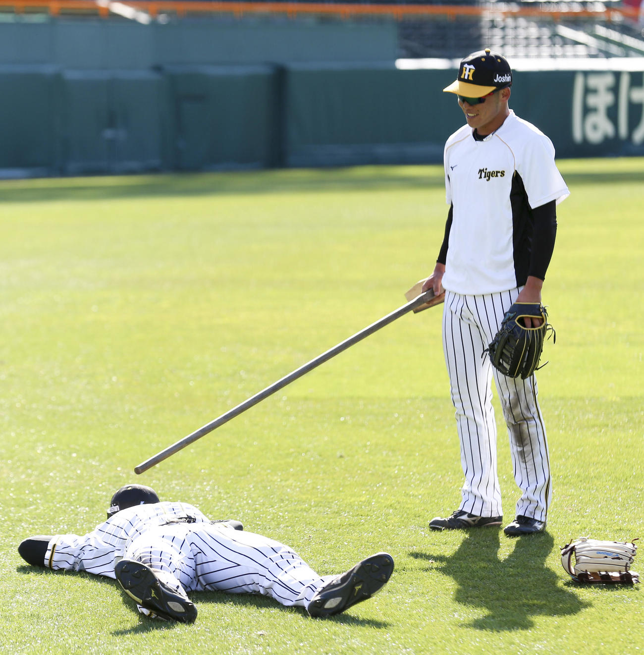 居残り特守を終え倒れ込む佐藤輝明（左）をトンボで小突く小野寺暖（撮影・上山淳一）