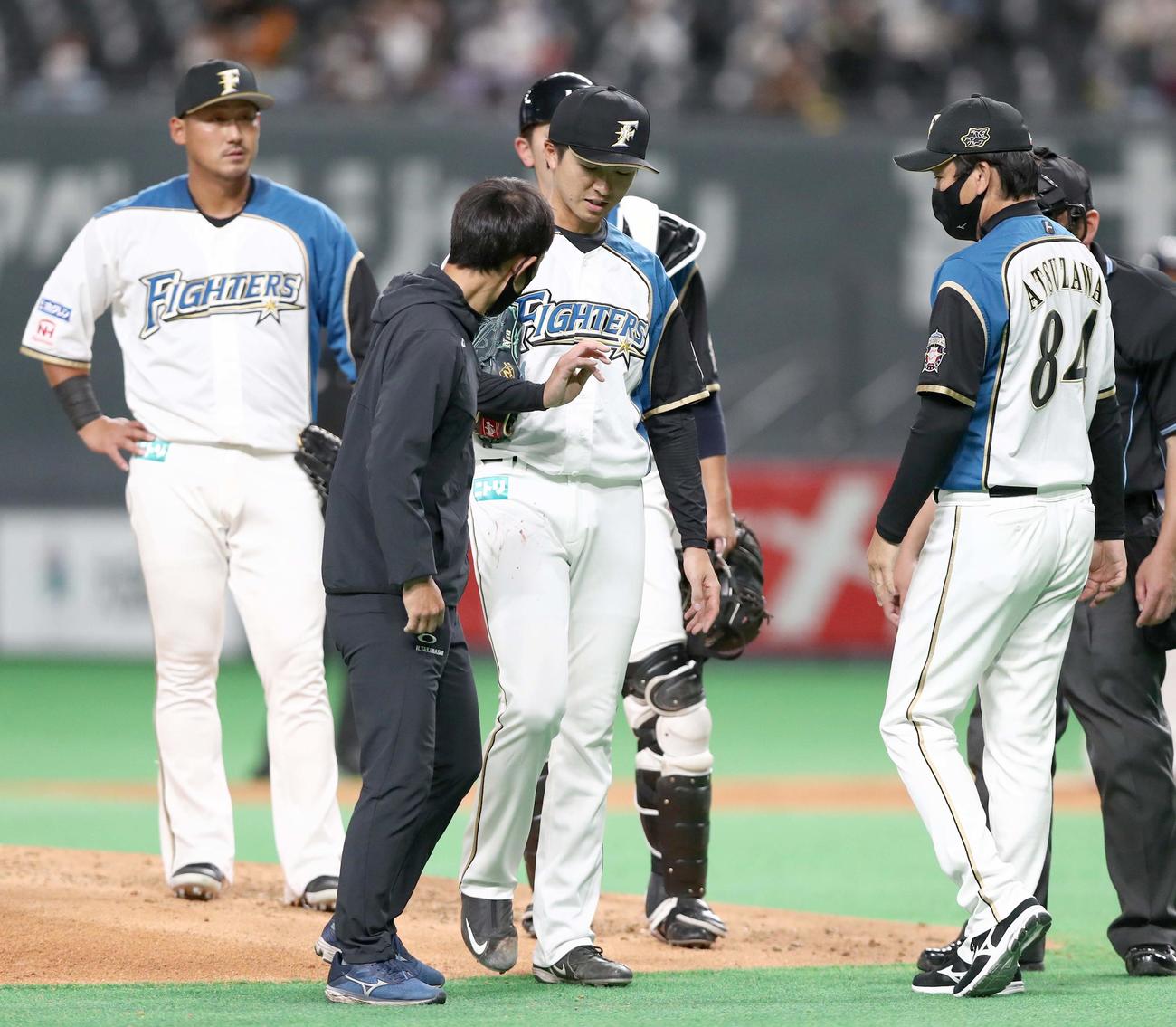 日本ハム対西武　3回表、右手薬指から出血し、一度ベンチへ戻る上沢（撮影・黒川智章）