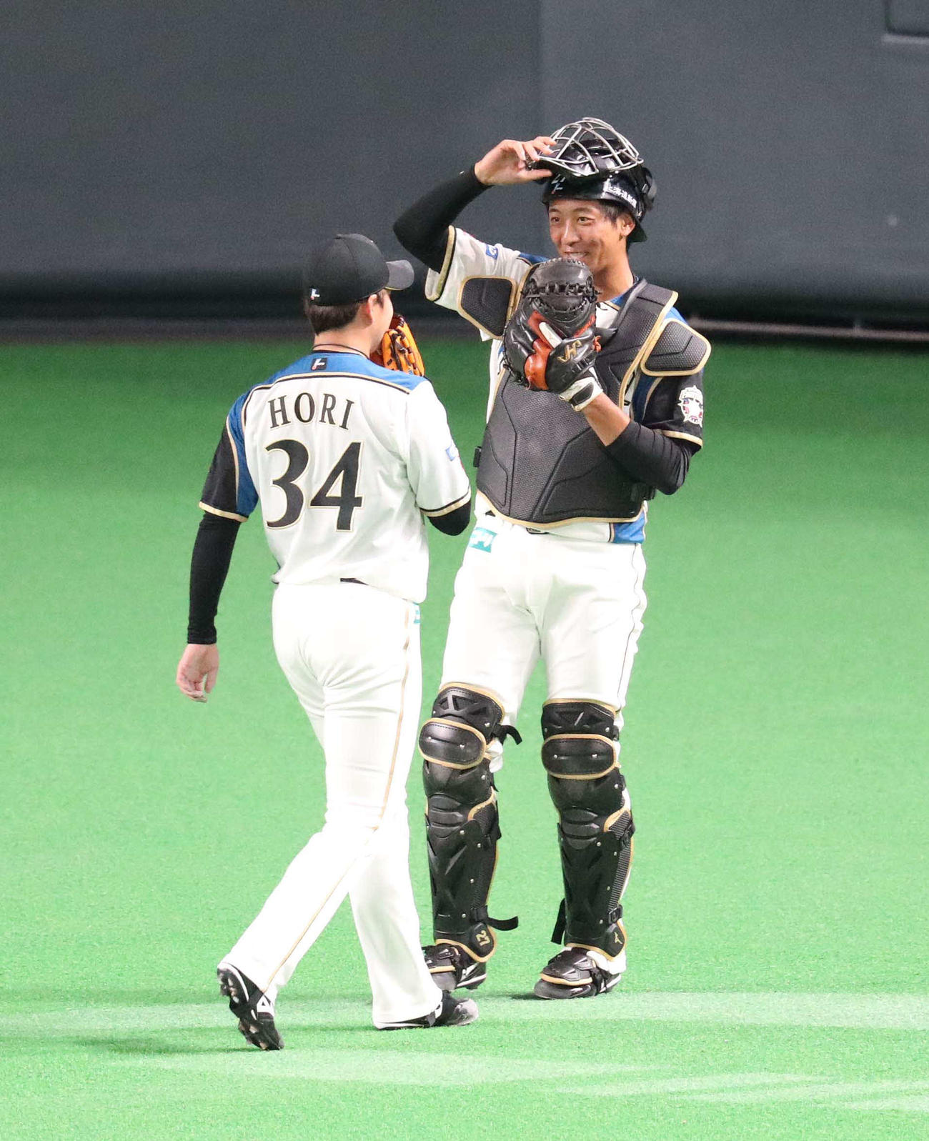 日本ハム対西武　7回表を無失点に抑え日本ハム堀（左手前）を笑顔で出迎える古川（撮影・佐藤翔太）